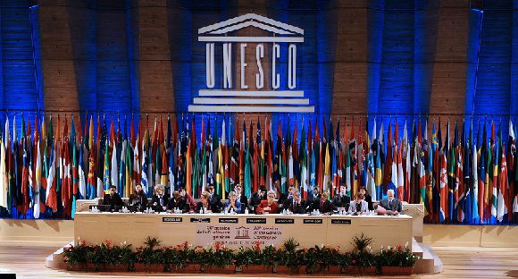 Caption: A picture taken on October 31, 2011 shows UNESCO managing director Irina Bokova of Bulgaria (first row, C, in blue) flanked by the Executive Board President Eleonora Valentinovna Mitrofanova (L) of Russia and the 36th Session President Katalina Bogyay of Hungary (R) ruling the vote for Palestinians to enter UNESCO as a full member at the headquarters of the organization in Paris. United Nations cultural agency UNESCO has been forced to suspend all its spending programmes until the end of the year after the United States withdrew its funding, its director general said on November 10, 2011. In an address to UNESCO diplomats, Irina Bokova said the agency faces a $65 million funding shortfall and would have to halt its activities, after a row with Washington over Palestinian membership. AFP PHOTO / MIGUEL MEDINA