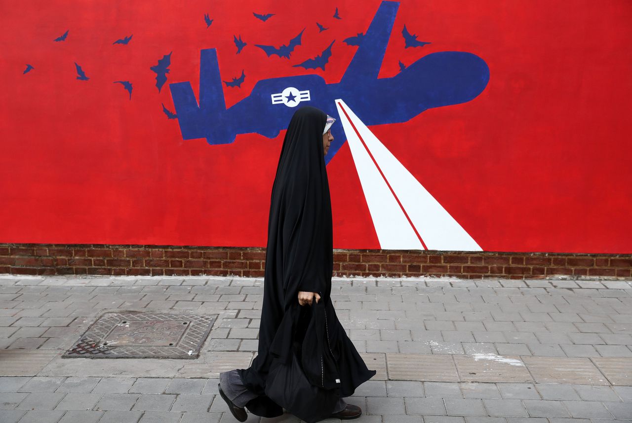 Een vrouw loopt in de hoofdstad Teheran langs een muurschildering van de Amerikaanse drone die eerder dit jaar door Iran uit de lucht werd geschoten.