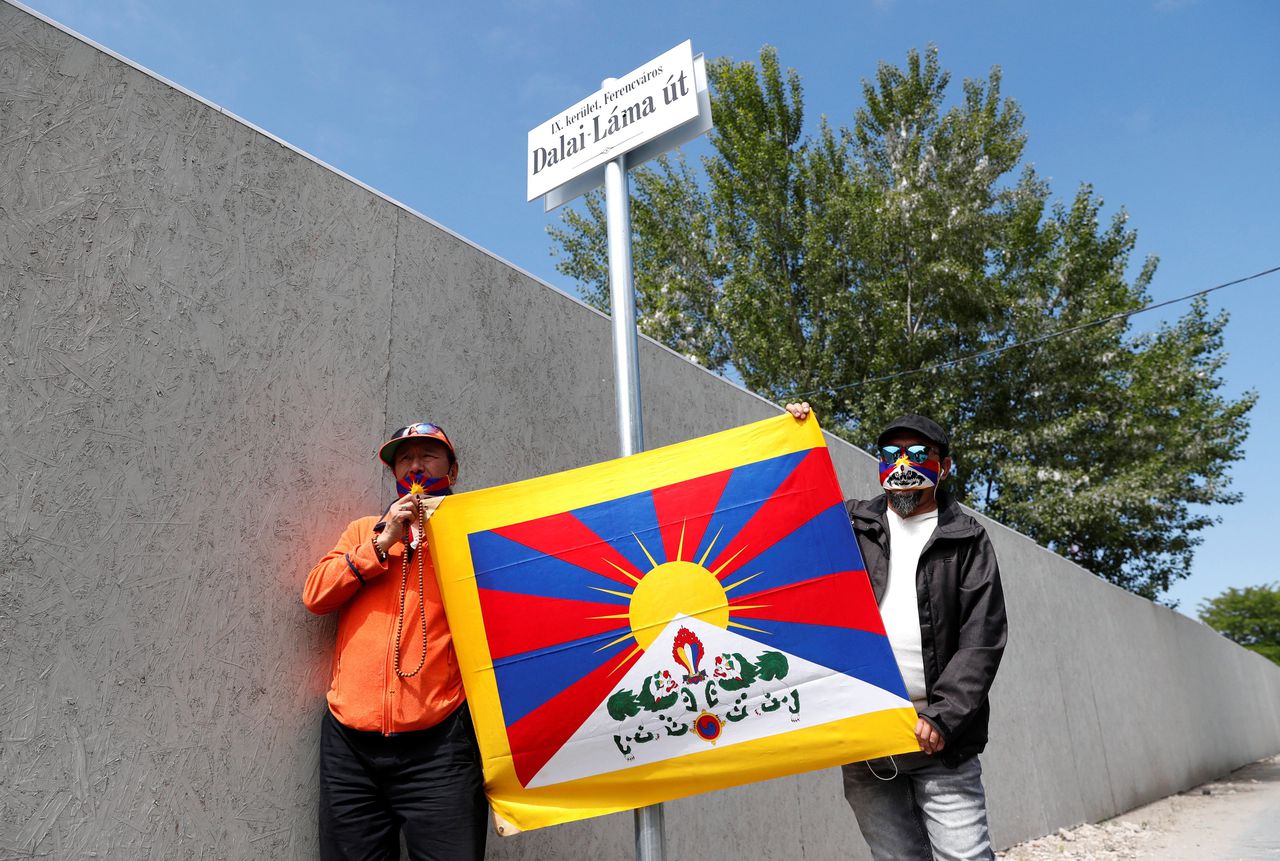 Activisten in Boedapest houden woensdag 2 juni een Tibetaanse vlag naast een straatbordje met daarop 'Dalai Lamastraat'.