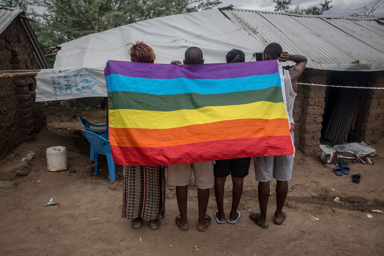 Oegandese homo-vluchtelingen poseren met een regenboogvlag in een beschermd deel van het Kakuma-vluchtelingenkamp, in het noordwesten van Kenia.