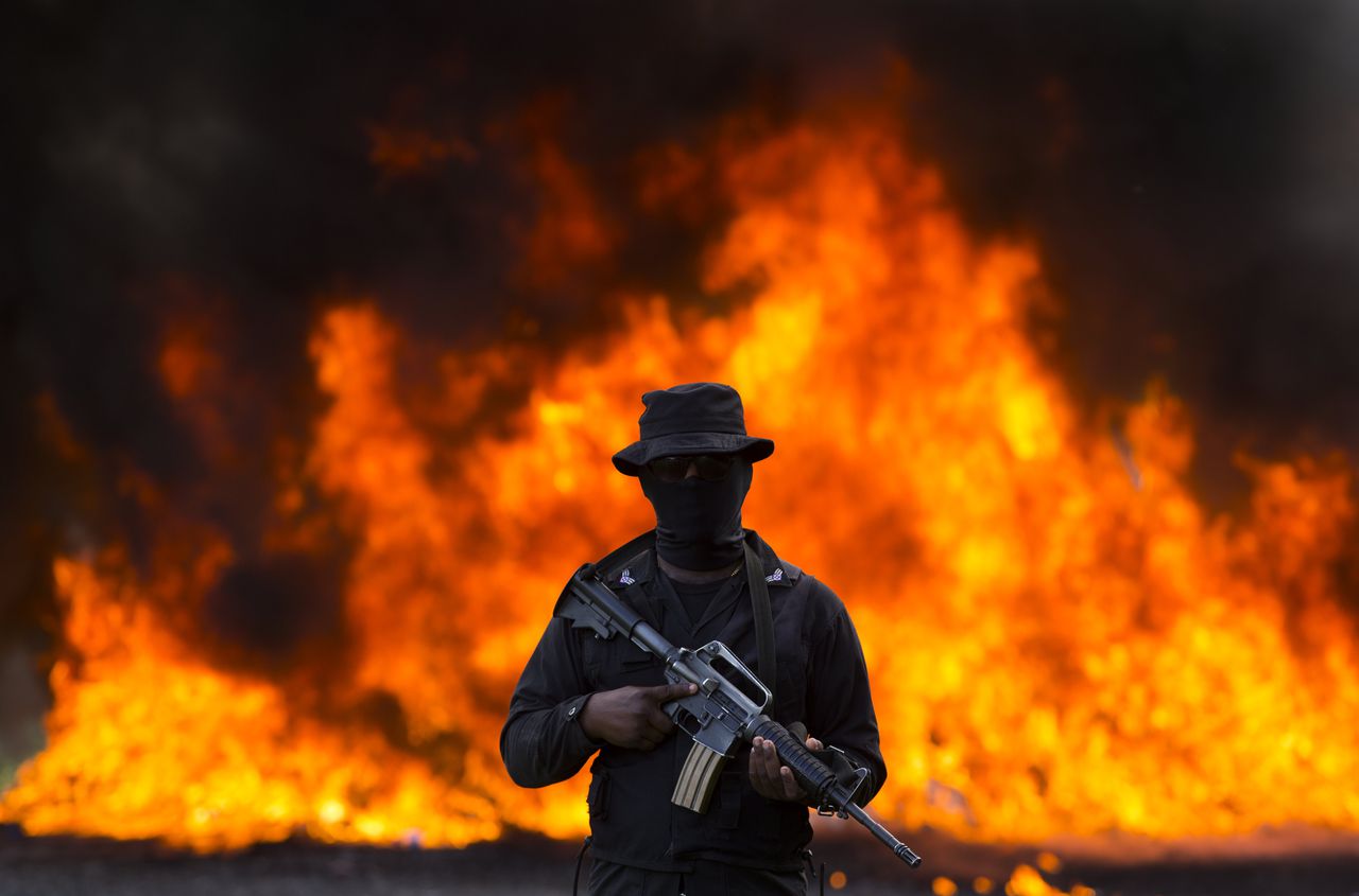 Een Dominicaanse agent houdt de wacht bij het verbranden van in beslagggenomen drugs.
