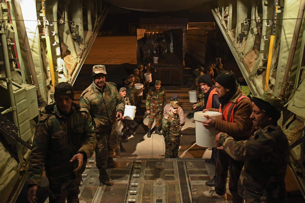 Syrische soldaten laden woensdag goederen uit afkomstig uit Irak na aankomst op het vliegveld van Aleppo.