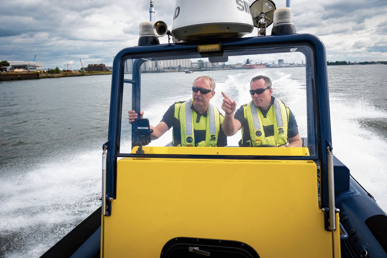 Scheepvaartmeesters Dick van de Pol (links) en Marcel de Vliegh op hun speedboot. „Mensen zijn verplicht ons aan boord toe te laten. Toch vragen we het altijd netjes.”