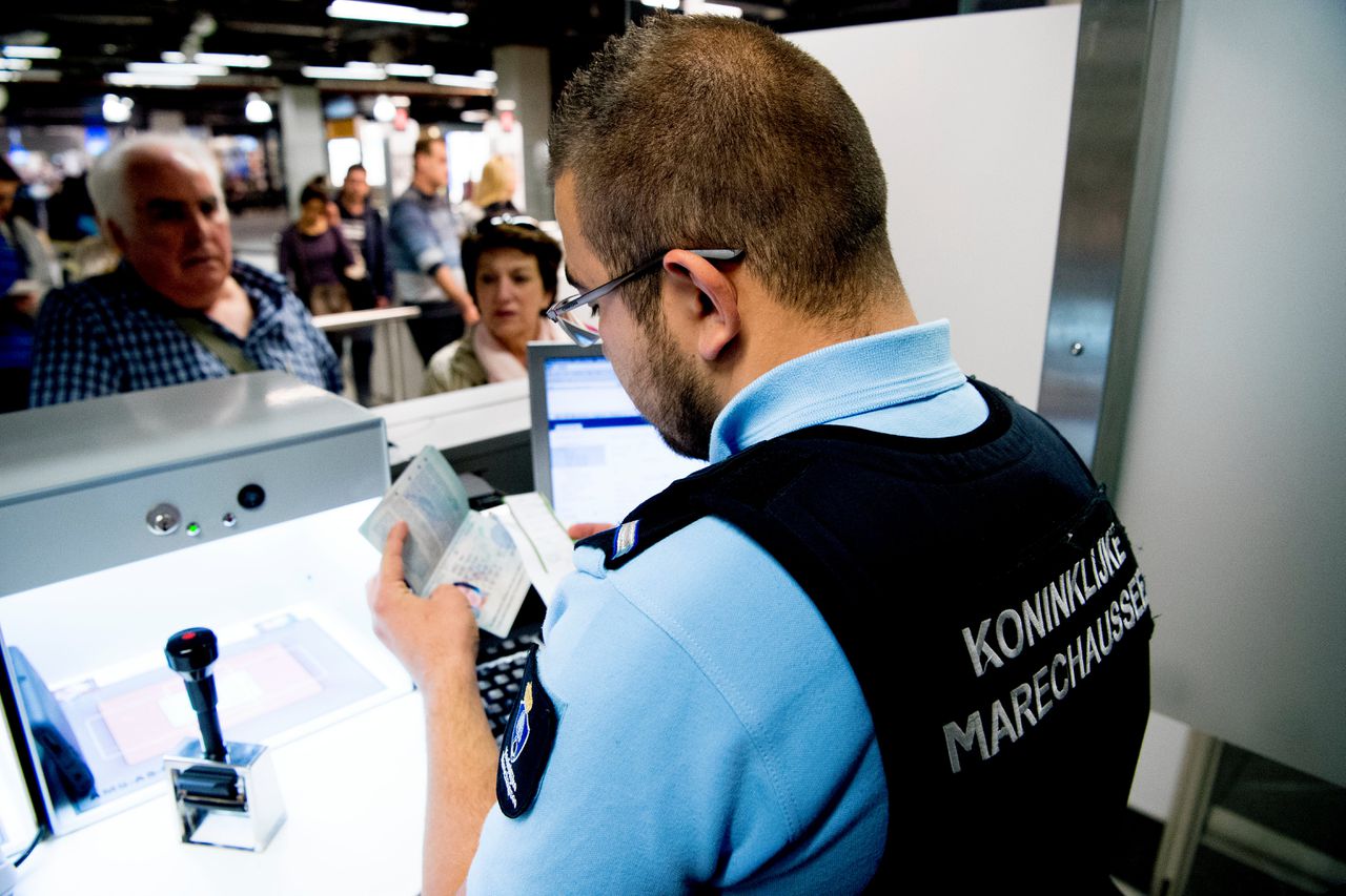 Paspoortcontrole door een marechaussee op Schiphol. Het systeem dat hiervoor gebruikt wordt is niet veilig genoeg, vindt de Rekenkamer.