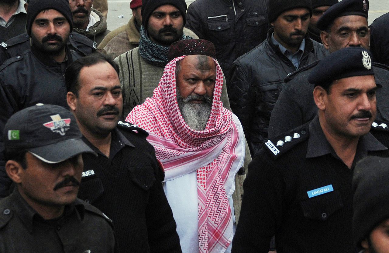 Malik Ishaq, de leider van de Pakistaanse terreurbeweging Lashkar-e-Jhangvi, hier op een archieffoto van december vorig jaar terwijl hij onder politiebegeleiding naar de rechtbank wordt gebracht. Ishaq kwam vanochtend om het leven tijdens een vuurgevecht tussen zijn aanhangers, die hem probeerden te bevrijden, en de politie.