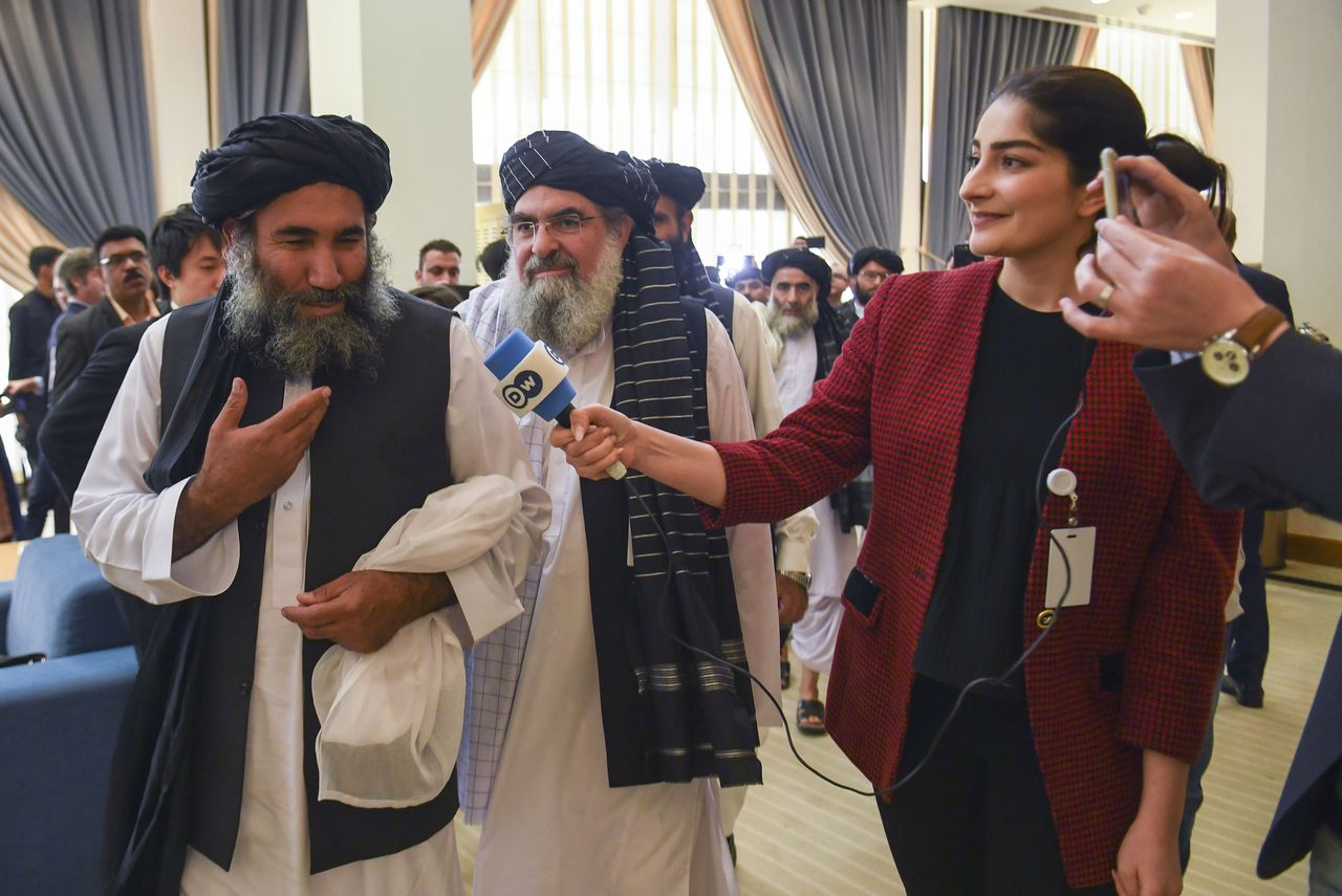 Een lid van de Taliban-delegatie spreekt in de Doha met de pers, vlak voor de ceremonie waarin de VS en de Taliban hun akkoord tekenen.