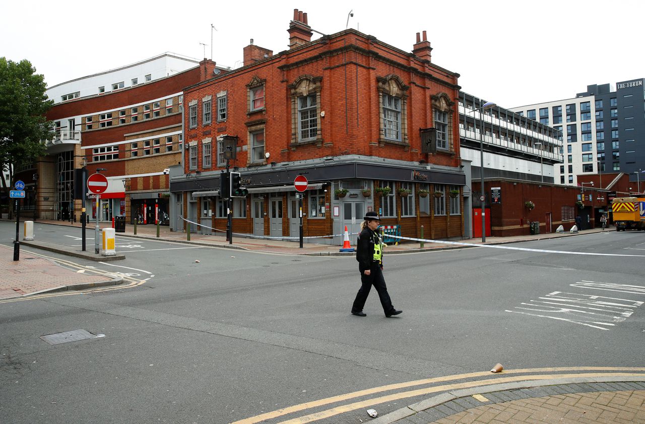 Een agent bewaakt een van de afzettingen in het centrum van Birmingham, waar onderzoek wordt gedaan naar de steekpartijen.