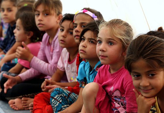 Kinderen die het geweld door IS in de Noord-Irakese stad Tal Afar zijn ontvlucht, in een geïmproviseerde school in een tent in het vluchtelingenkamp Bahrka, in de autonome Koerdische regio. Daar zijn naar schatting 700.000 gevluchte Irakezen.