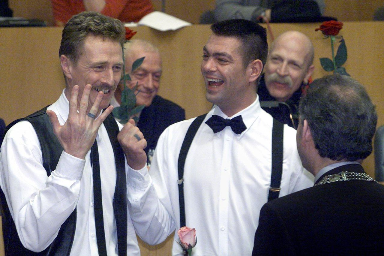 Frank Wittebrood (l) en Peter Lemke behoorden tot de eerste vier homoparen die op 1 april 2001, als eerste ter wereld, in het huwelijk met elkaar traden. Op de foto tonen zij hun getatoeëerde ringen aan de Amsterdamse burgemeester Job Cohen, die het huwelijk voltrok.