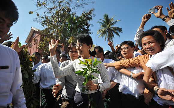 (FILES) This file picture taken on January 18, 2012 shows Myanmar democracy icon Aung San Suu Kyi (C) waving to supporters as she leaves the Thanlyin township election commission office after she registered to run as a candidate in upcoming by-elections, on the outskirts of Yangon. With the fighting peacock flag flying outside, Aung San Suu Kyi's Yangon party headquarters are once again a hive of activity as her Myanmar opposition prepares for its first poll battle in two decades. The excited crowds that gathered around the democracy icon this week as she registered her candidacy for April 1 by-elections testified to the new energy galvanising Myanmar's politics after almost half a century of military rule. AFP PHOTO/Soe Than WIN