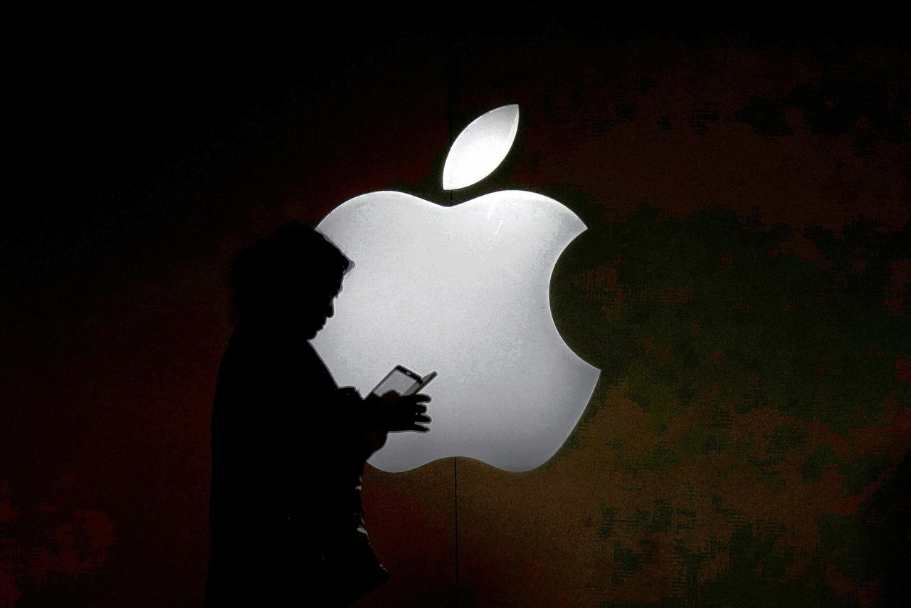 Een vrouw kijkt op haar iPhone voor een logo van Apple.