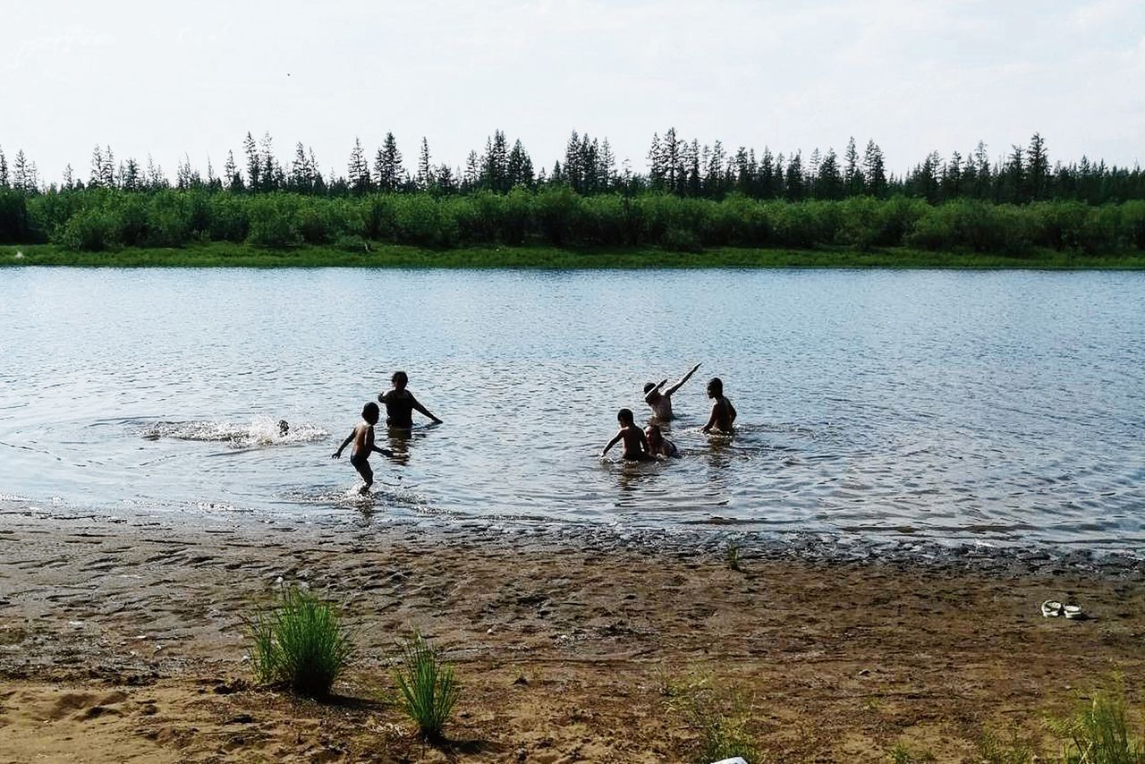 Kinderen spelen in een meer net buiten het Siberische stadje Verchojansk, waar het afgelopen zaterdag 38 graden Celsius werd, de hoogst gemeten temperatuur in het gebied boven de Noordpoolcirkel.