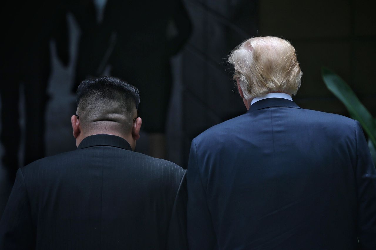 Kim Jong-un (L) en Donald Trump (R) lopen samen rond tijdens een pauze tussen de gesprekken in Singapore.