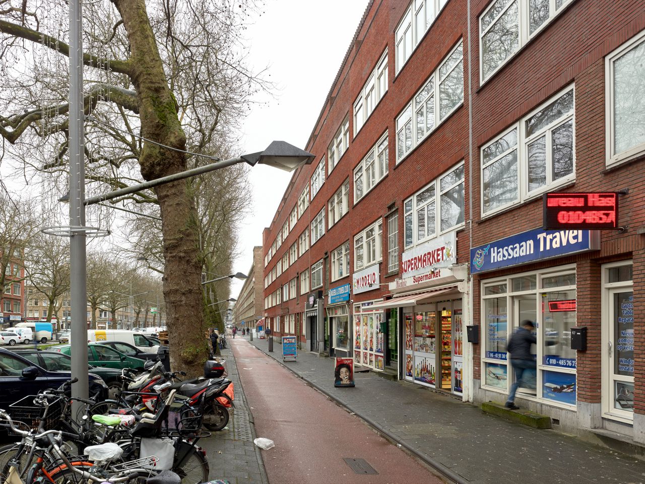 Een straat in Rotterdam met een Poolse supermarkt en een reisbureau voor islamitische bedevaarttochten.