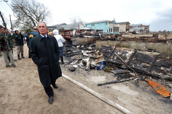 Michael Bloomberg neemt de schade op in de buurt Breezy Point, Queens, waar meer dan vijftig huizen in de as werden gelegd door een grote brand, veroorzaakt door orkaan Sandy.