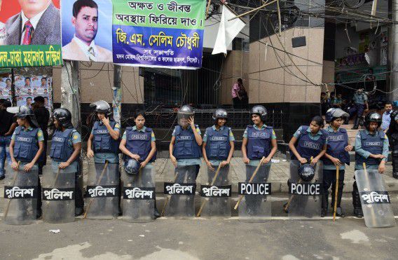 Politieagenten in Dhaka staan op wacht tijdens een algemene staking gisteren die werd uitgeroepen door de achttien oppositiepartijen. Sinds het oorlogstribunaal dit jaar van start ging, wordt Bangladesh geplaagd door de hevigste rellen in twintig jaar.
