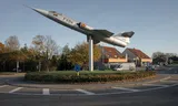 In het Vlaamse Kleine-Brogel staat een F-104 Starfighter op een rotonde, een herinnering aan de Belgische militaire luchtvaartgeschiedenis tijdens de Koude Oorlog.