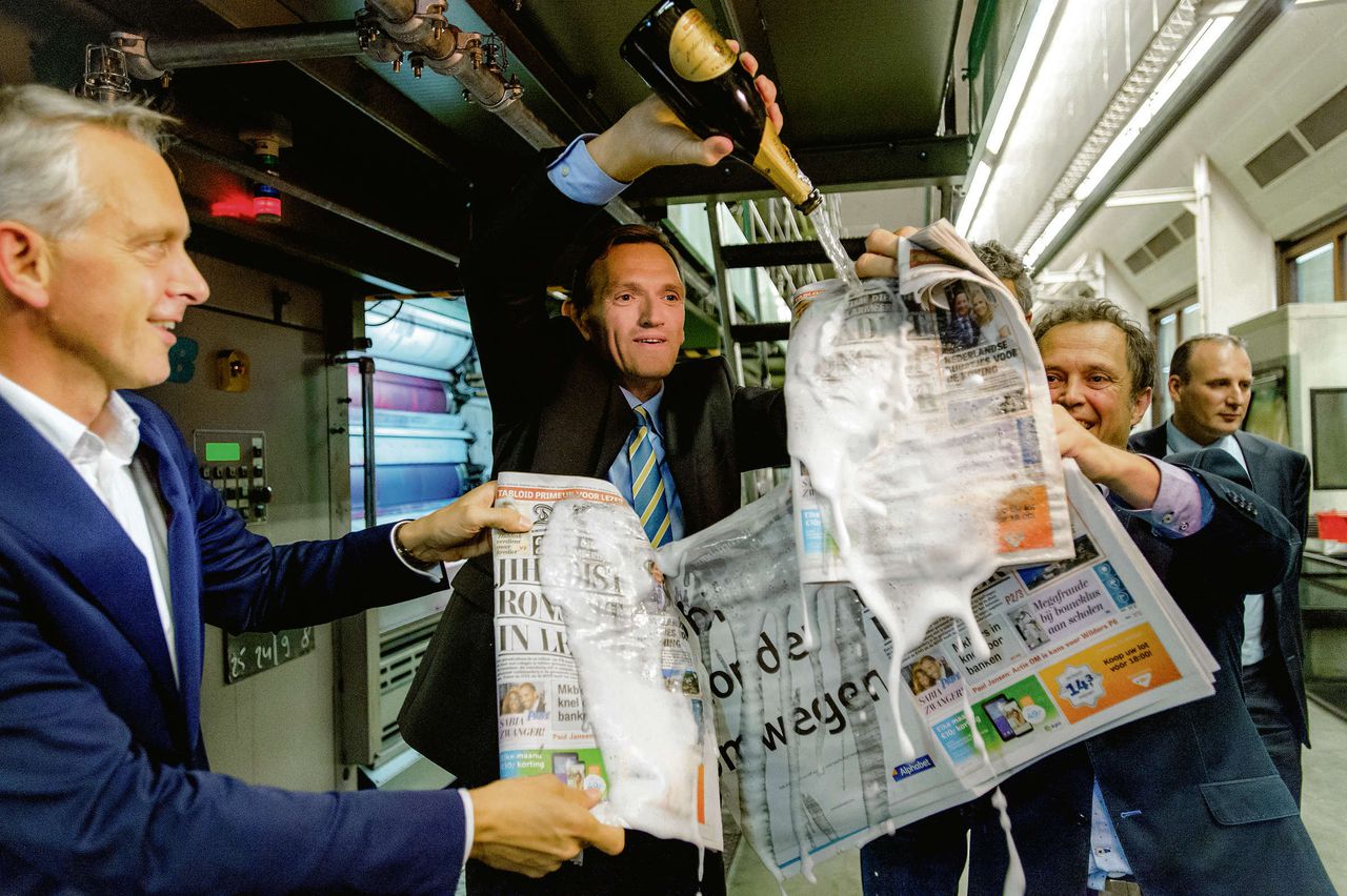 TMG’s bestuursvoorzitter Geert-Jan van der Snoek (links) en hoofdredacteurSjuul Paradijs dopen in de nacht van 9 op 10 oktober het eerste exemplaar van De Telegraaf op tabloid.