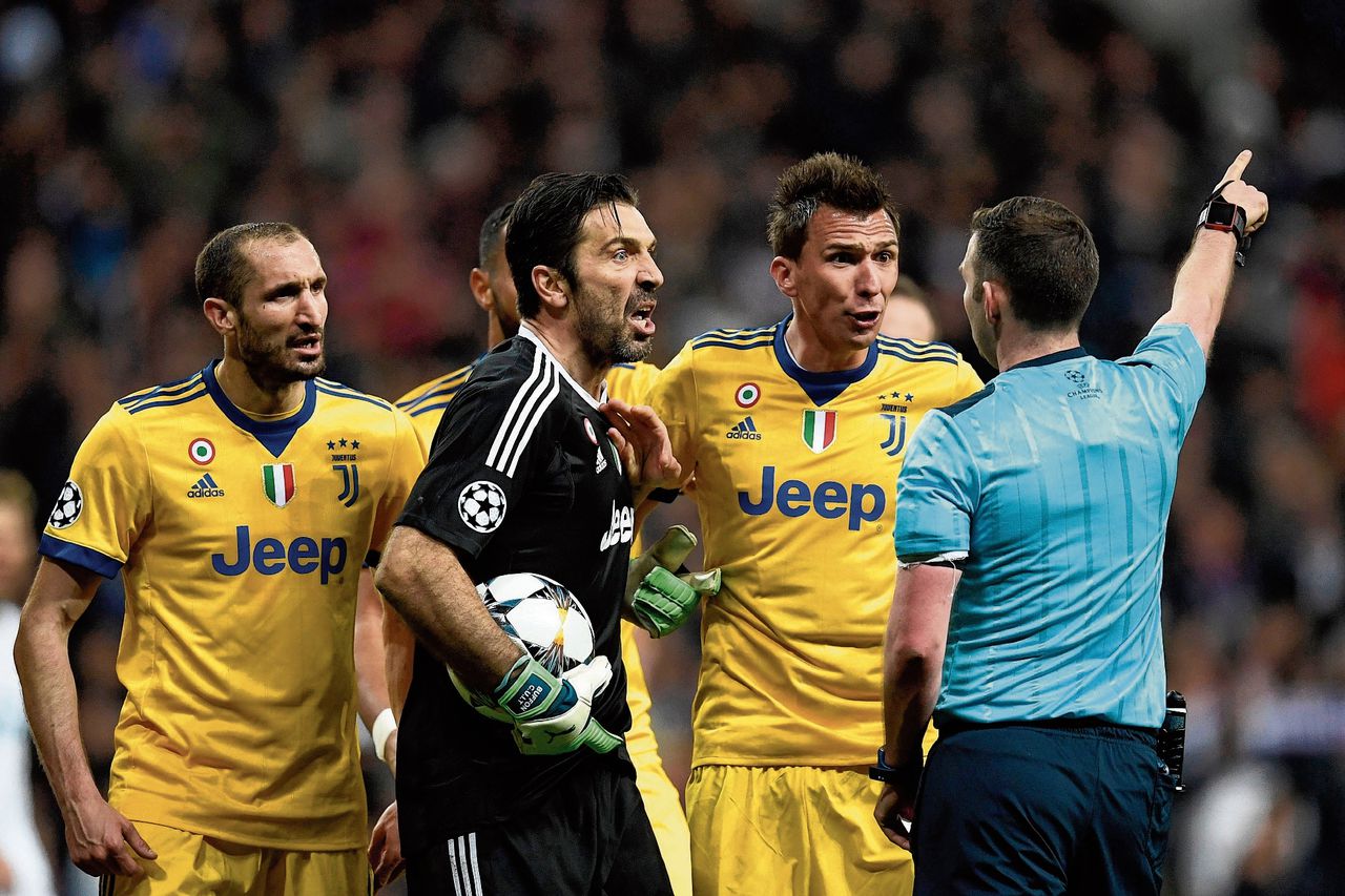 Keeper Gianluigi Buffon (in het zwart) van Juventus is woest als hij in de slotfase van het duel tegen Real Madrid rood krijgt van arbiter Michael Oliver (rechts).