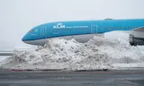 Een vliegtuig van KLM in de sneeuw op Schiphol.