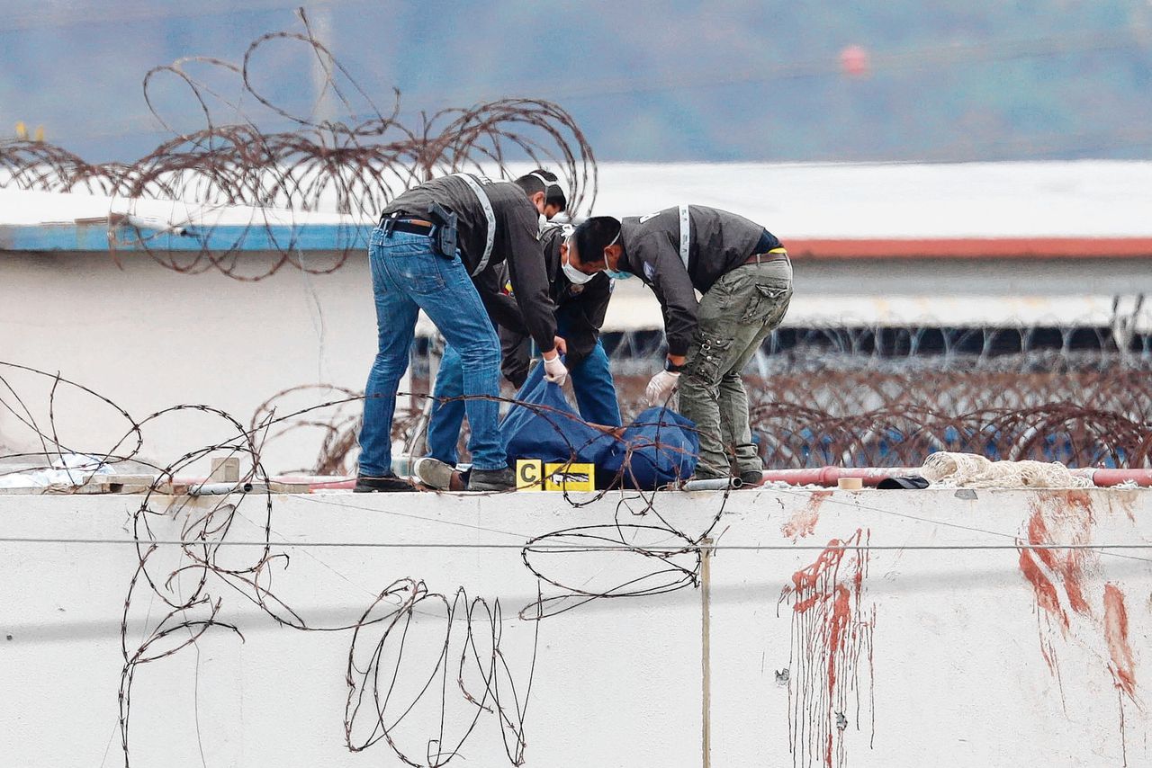 Agenten verwijderen een dode van het gevangenisdak in Guayaquil.