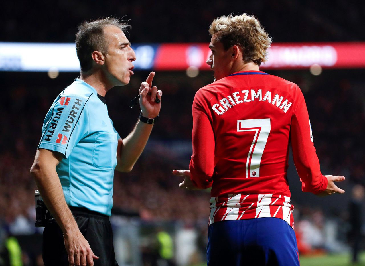Scheidsrechter David Fernandez Borbalan in discussie met de Franse spits Antoine Griezmann, die voor Atlético Madrid speelt.