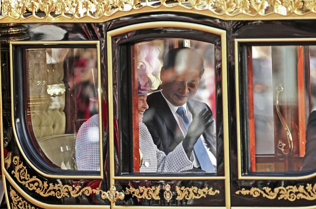 De Britse koningin Elizabeth en de Chinese president Xi Jinping, gisteren op weg naar Buckingham Palace in Londen.