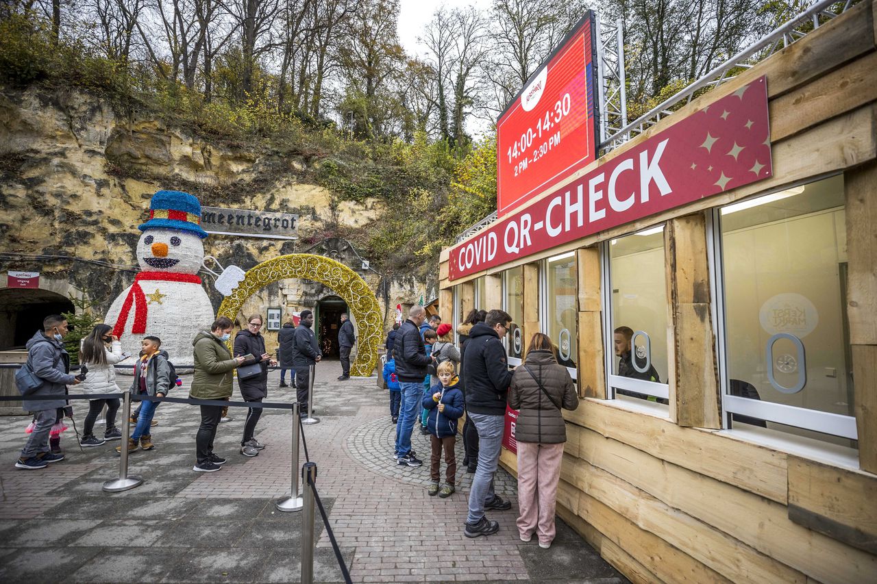 Bezoekers van de jaarlijkse kerstmarkt in de grotten van Valkenburg laten hun coronapas scannen.