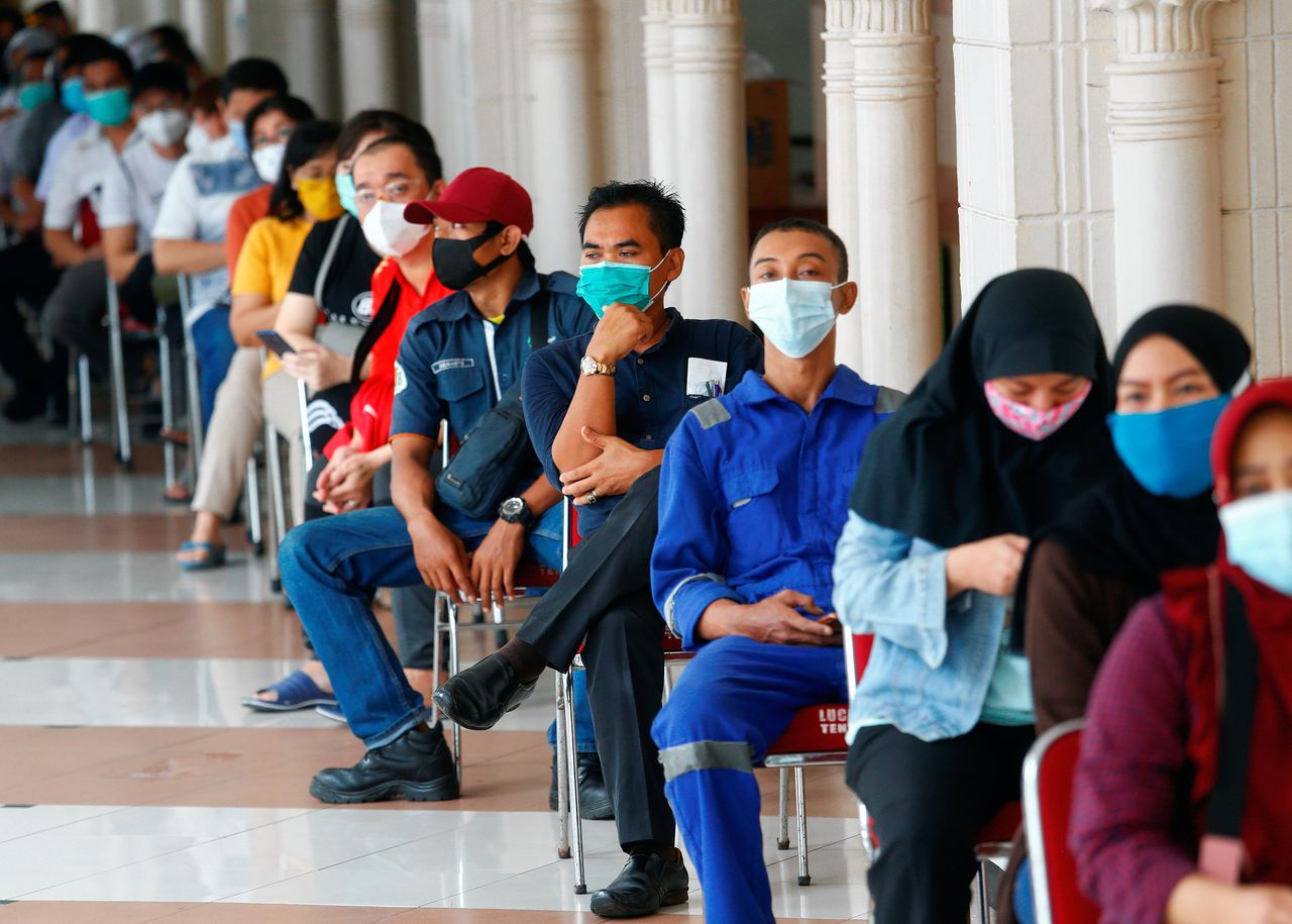 Inwoners van Jakarta wachten op hun vaccinatie met het Chinese vaccin Sinovac in de Tanah Abang textielmarkt, 17 februari.