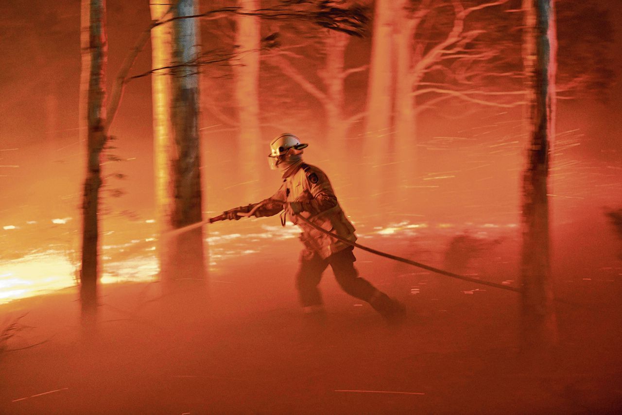 Een brandweerman probeert de huizen van Nowra te beschermen.