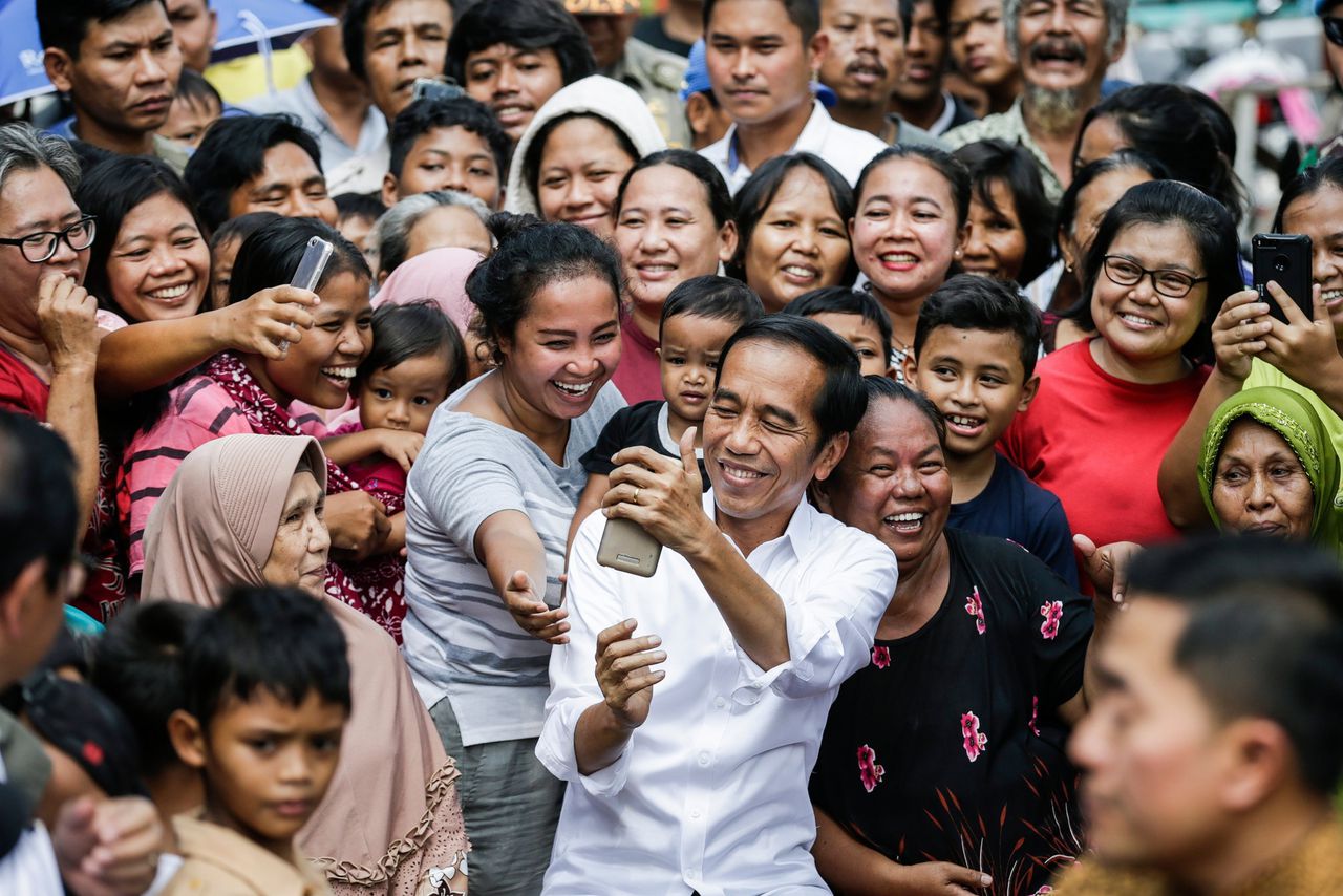 Zittend president Joko Widodo maakt een selfie nadat hij de verkiezingen heeft gewonnen.