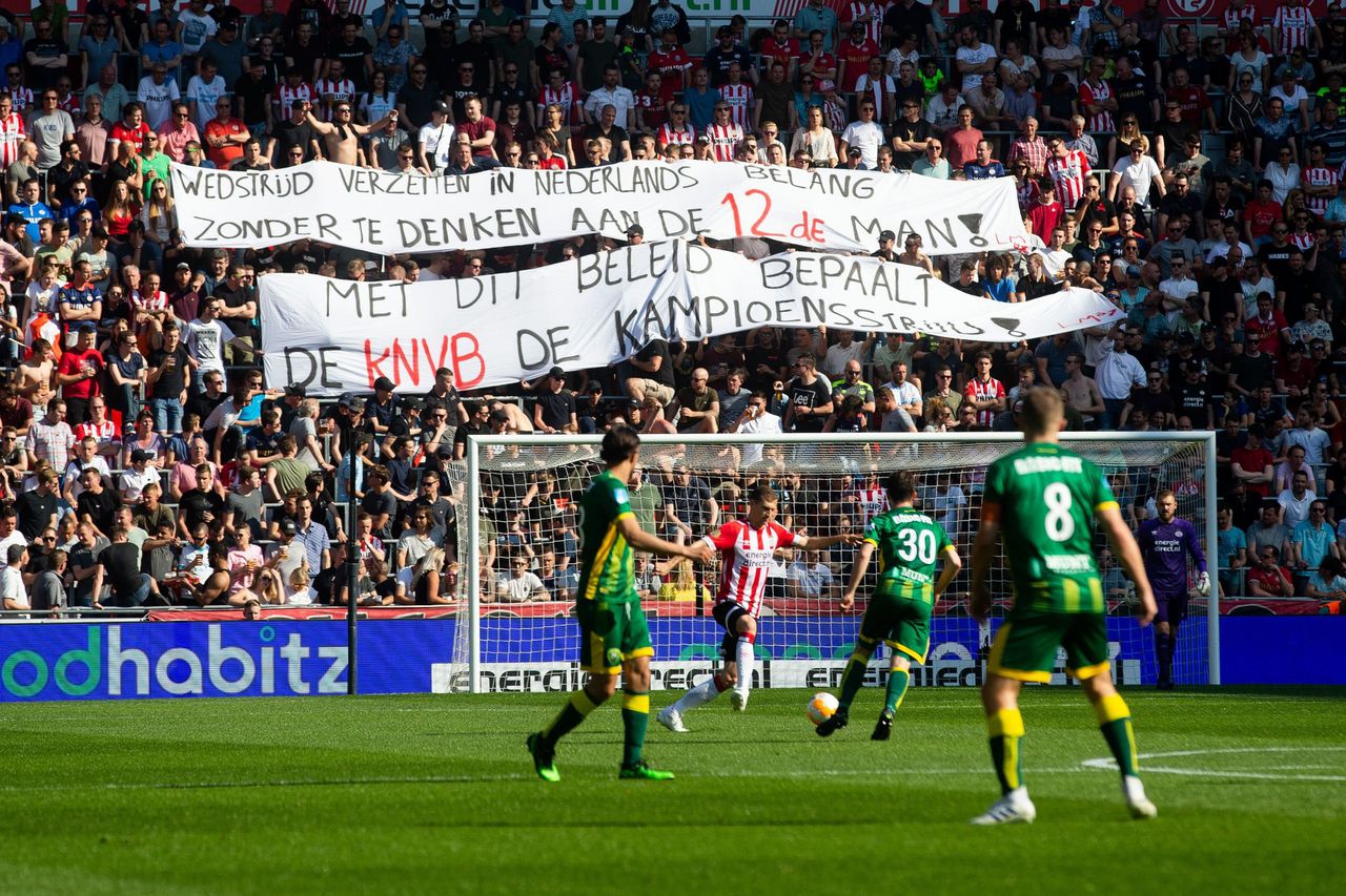 PSV-supporters protesteren met spandoeken tegen de verplaatsing van speelronde 33, die nu op woensdag 15 mei wordt gespeeld.