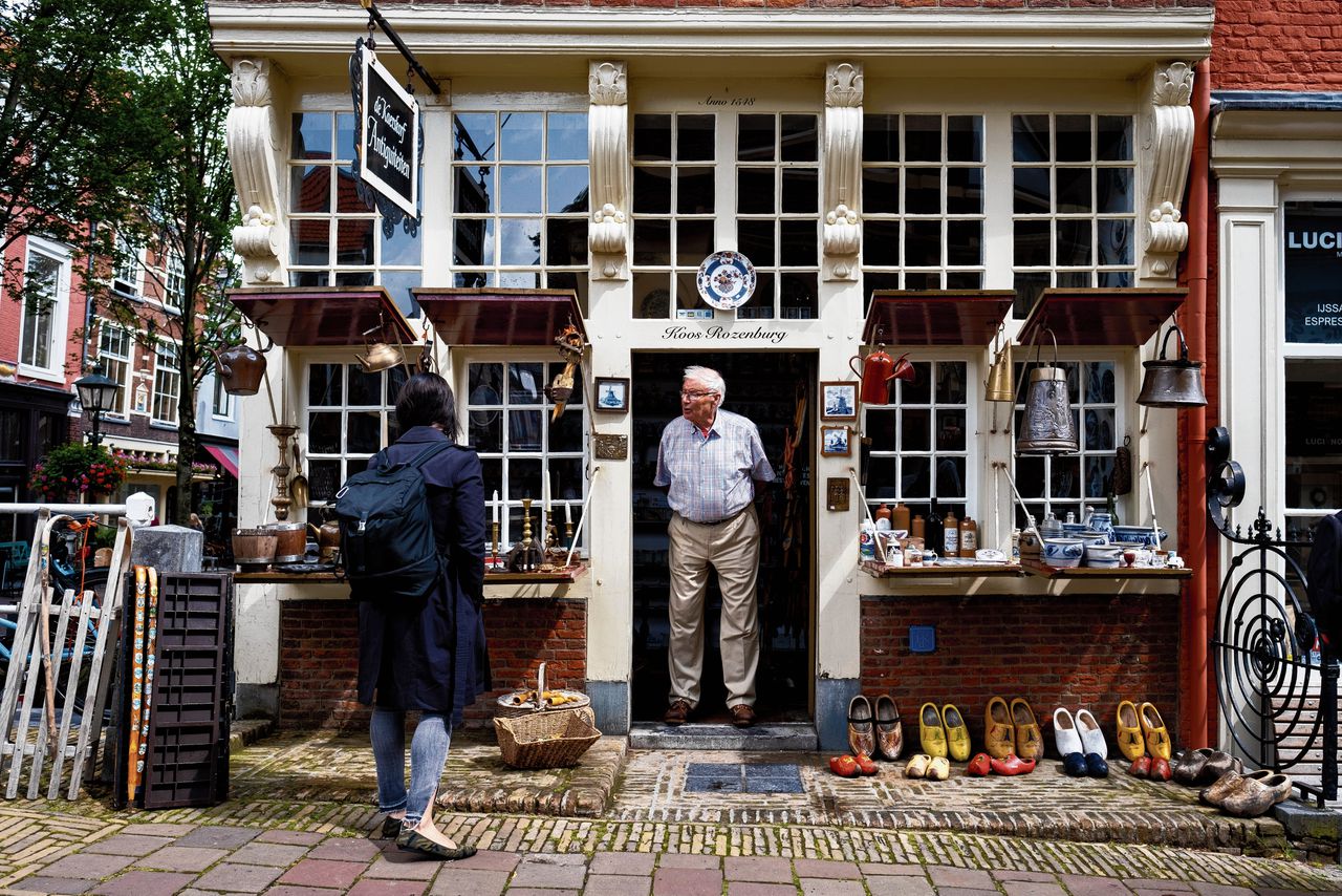 Koos Rozenburg (87) bij zijn antiekwinkel. Sinds de Chinezen en Amerikanen door corona niet meer naar Delft komen, gaat het slecht met de handel in Delfts Blauw.