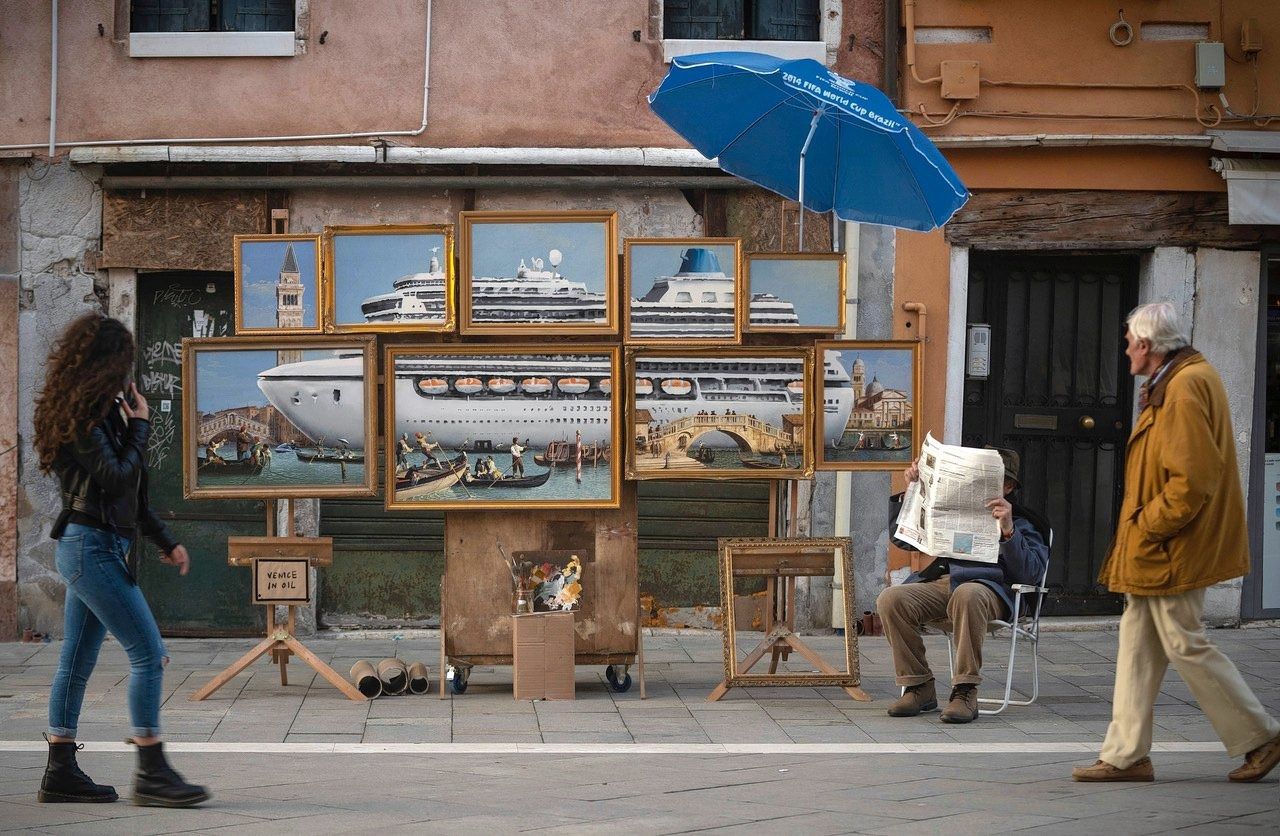‘Venice in oil’ van Banksy op het San Marcoplein in Venetië, met ernaast achter de krant (mogelijk) de kunstenaar zelf.