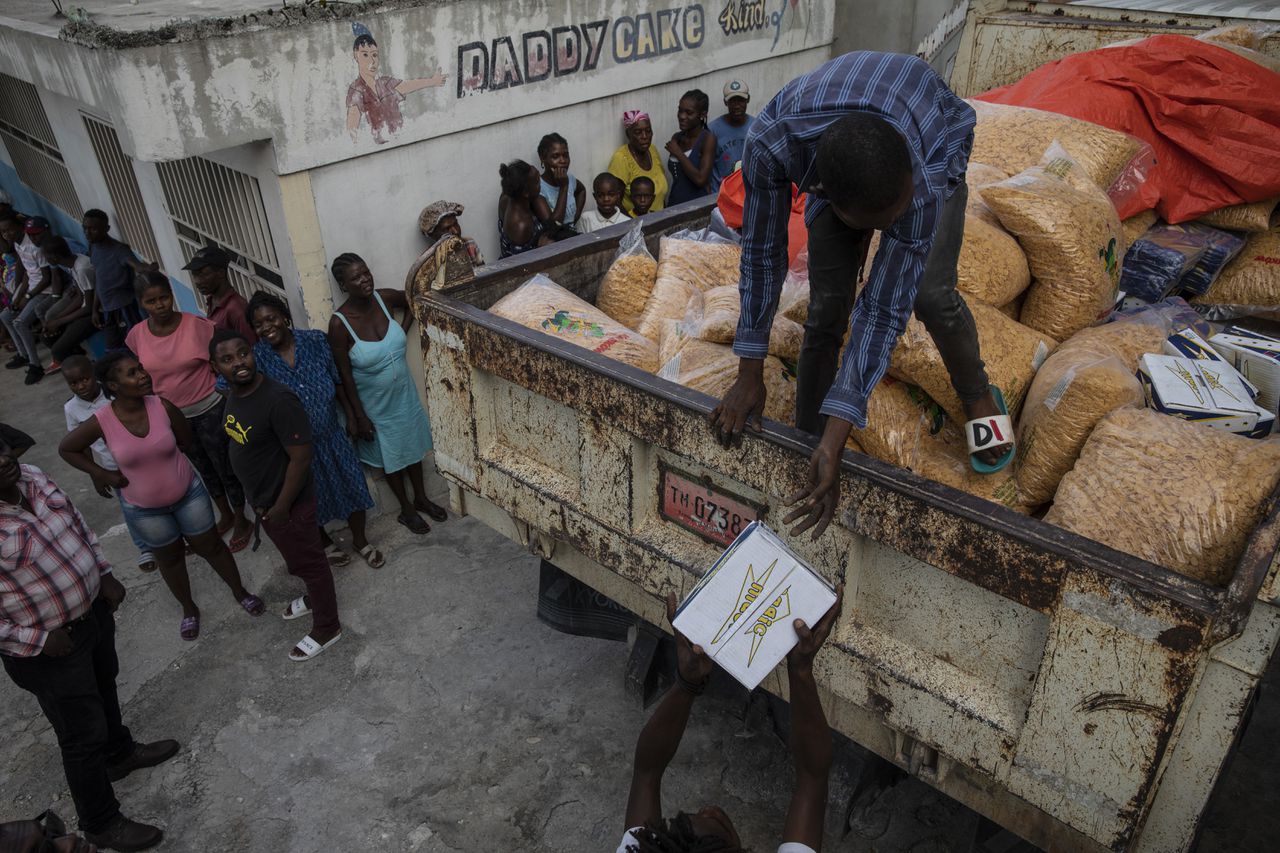 Mensen delen voedsel uit in de Haïtiaanse hoofdstad Port-au-Prince.