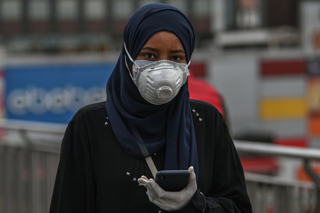 Een vrouw draagt twee mondkapjes en handschoenen in Istanbul.