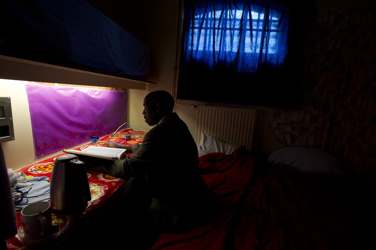 Een uitgeprocedeerde asielzoeker leest de koran op zijn kamer in de zogeheten Vluchthaven in 2014.