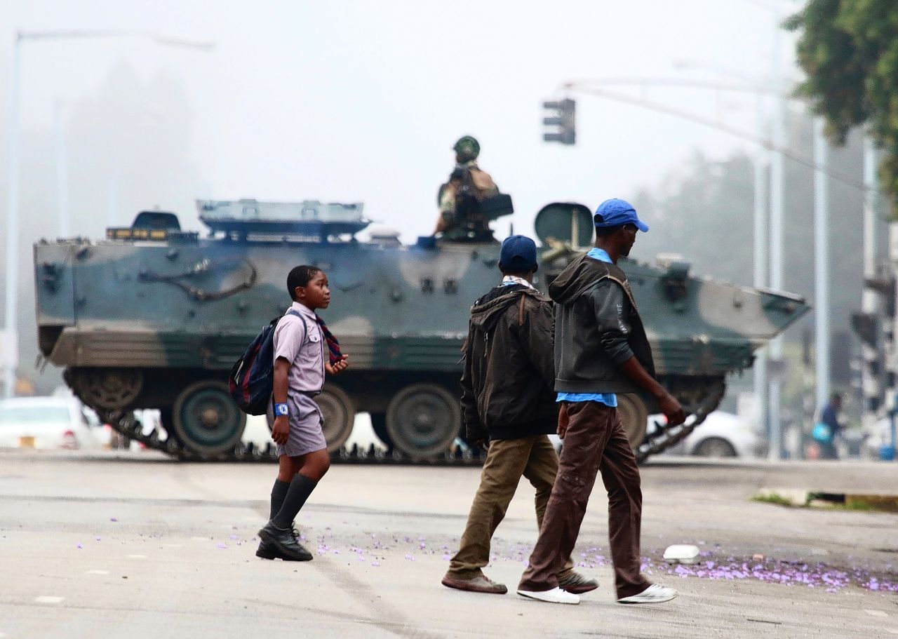 Een patrouille door militairen in Harare. Op de voorgrond lopen burgers.