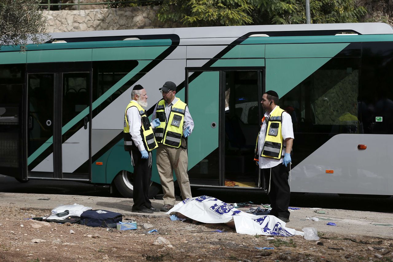 Leden van de Israëlische veiligheidsdiensten staan bij de bus waar twee personen het vuur openden en instaken op passagiers.