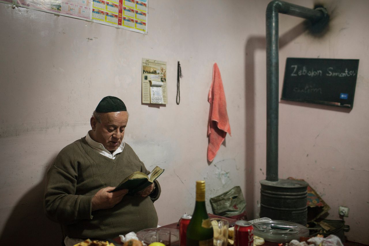 Zabulon Simantov leest een boek in zijn huis naast de synagoge in Kabul, in 2012.