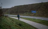 Een vluchteling loopt langs de weg in de buurt van het azc in Ter Apel.  