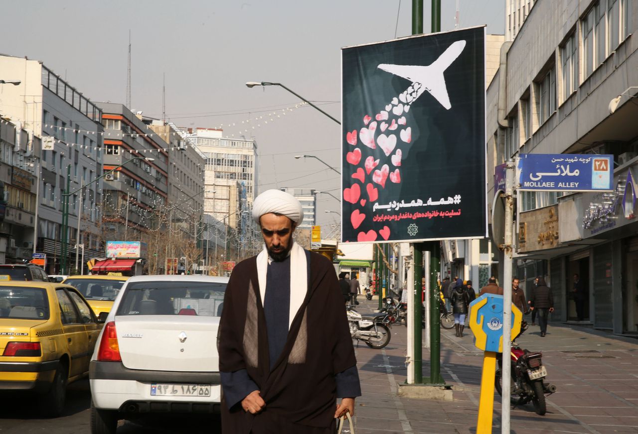 Een Iraniër loopt in Teheran langs een poster die de slachtoffers van het neergeschoten passagierstoestel van Ukraine International Airlines herdenkt.