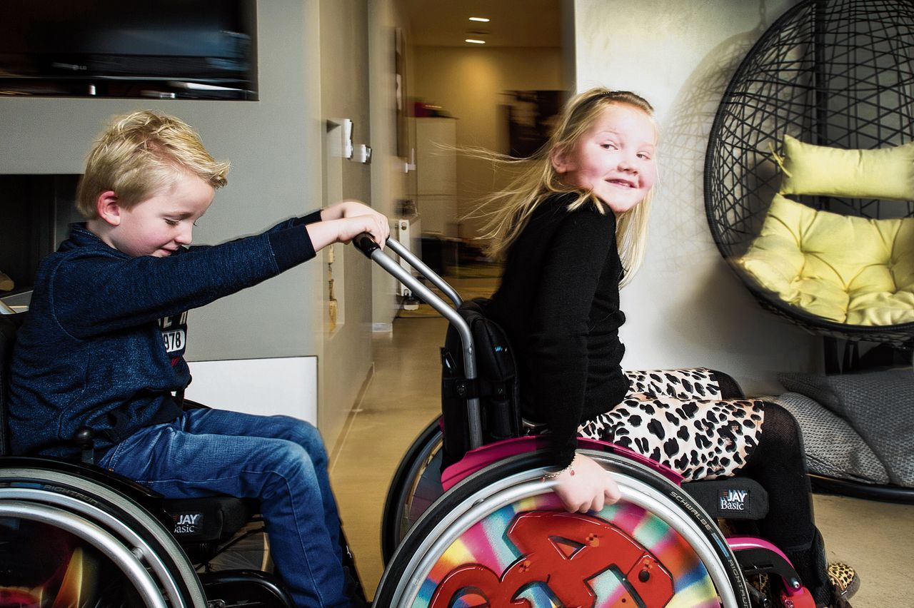 Luka Wolters (5) duwt zijn zusje Mara (8). Door hun spierziekte kunnen de kinderen alleen korte afstanden lopen.