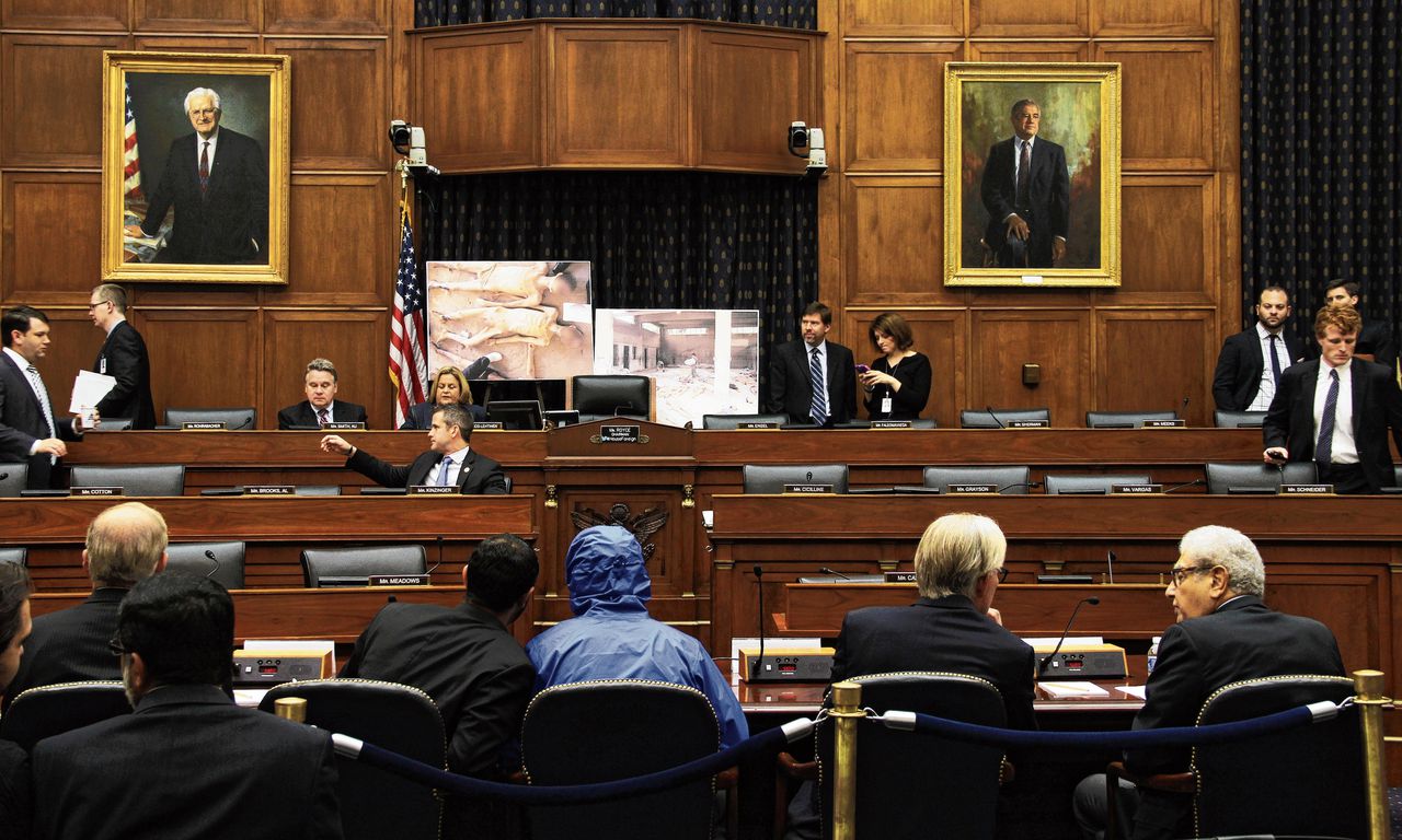 De uitgeweken Syrische fotograaf ‘Caesar’ (met blauw jack) geeft in 2014 een toelichting in het Amerikaanse Huis van Afgevaardigden op de door hem genomen foto’s van lijken met tekenen van martelingen.