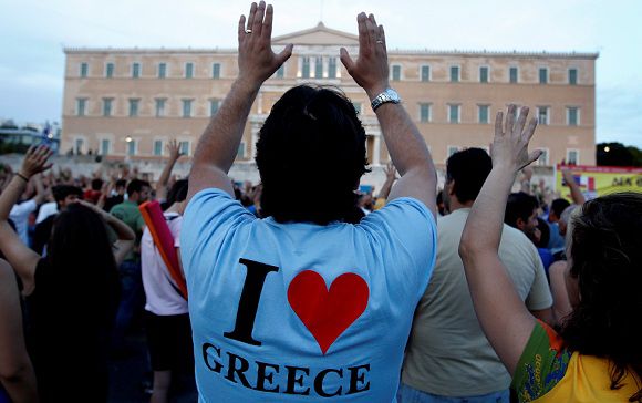 Caption: Protesters gesture behind the Greek Parliament during a peaceful rally for a 13th day, called through a social networking site in Athens, on Monday, June 6, 2011. Greece's prime minister embarked on a drive Monday to push new austerity plans through Parliament, despite increasing dissent within his party and big demonstrations in the country's two largest cities (AP Photo/Petros Giannakouris)