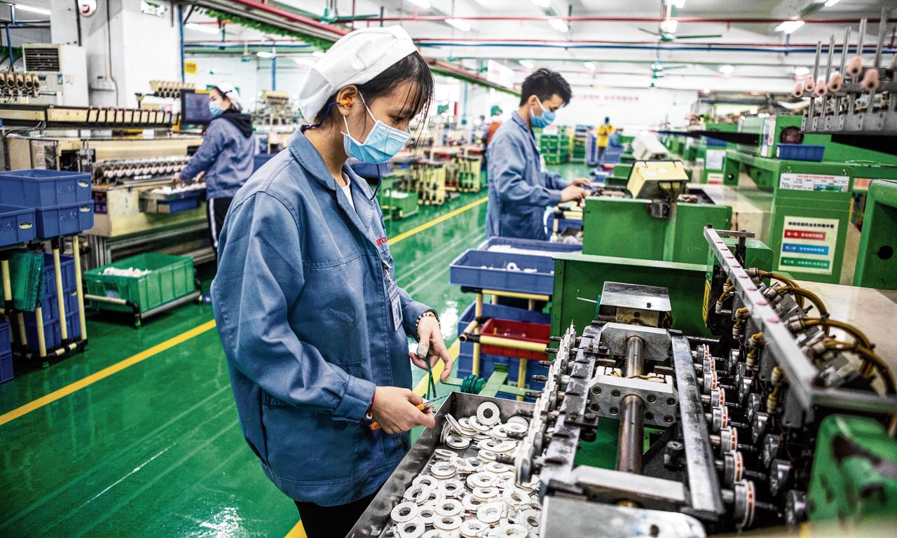 In de Galanz-fabriek in het Chinese Foshan komt de productie deels weer op gang, al moet het personeel zich aan strikte voorschriften houden.