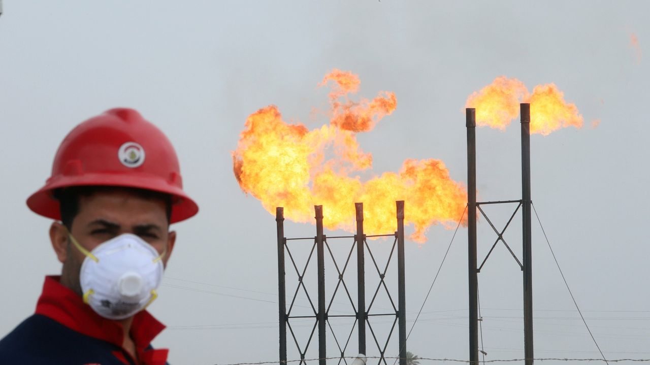 Een oliewerker met mondkapje, op het Nahr Bin Umar-olieveld ten noorden van Basra in Irak.