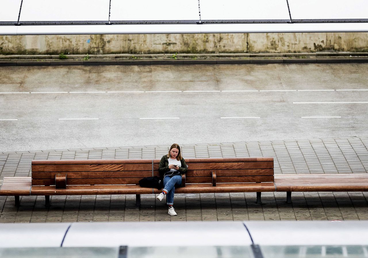 Een eenzame reiziger bij het busstation Jaarbeurs wacht op vervoer tijdens de landelijke staking van het regiovervoer op 30 april.
