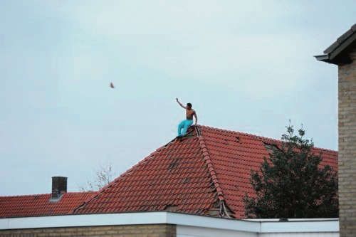 Een verwarde man gooit pannen van een dak in Echt, 2014