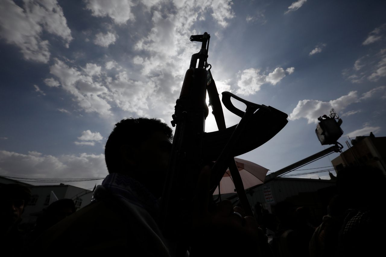 Een Houthi-strijder houdt zijn wapen omhoog in de Jemenitische hoofdstad Saana.